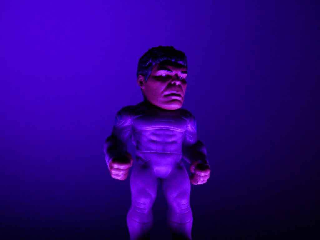 Action figure dengan sorotan cahaya berwarna ungu